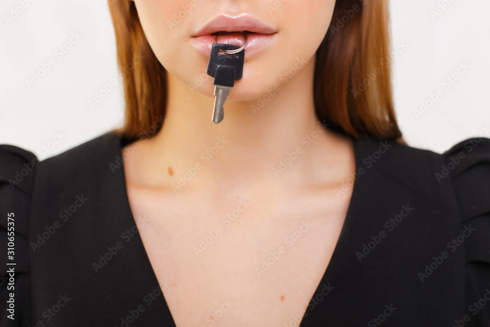 Closeup portrait of woman silent with a key in her mouth. Women's secrets. Silence is golden. Closeup portrait of woman silent with a key in her mouth. Women's secrets. Silence is golden.