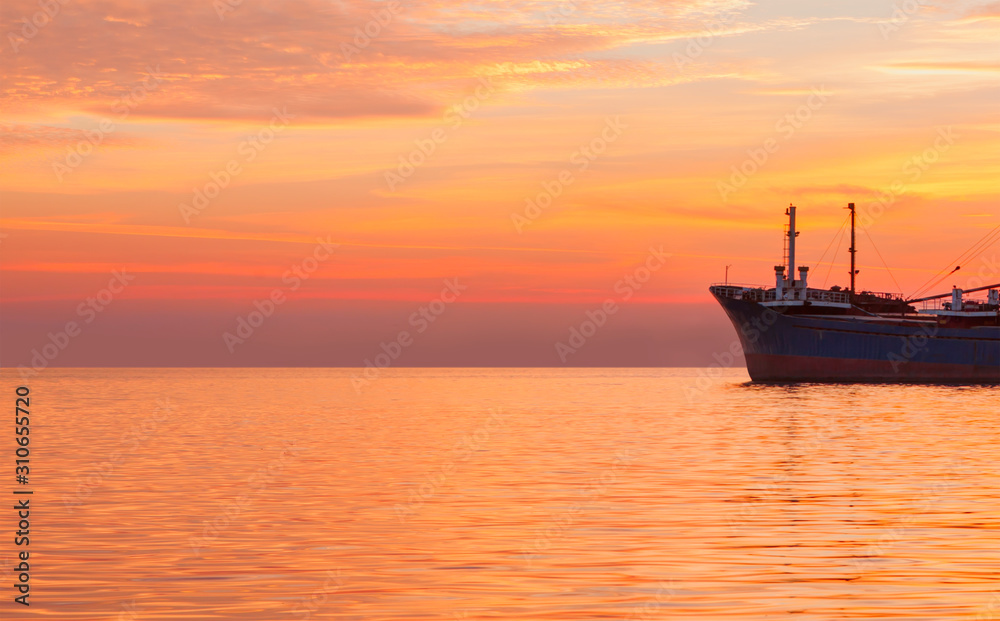 big merchant ship on the see at sunset