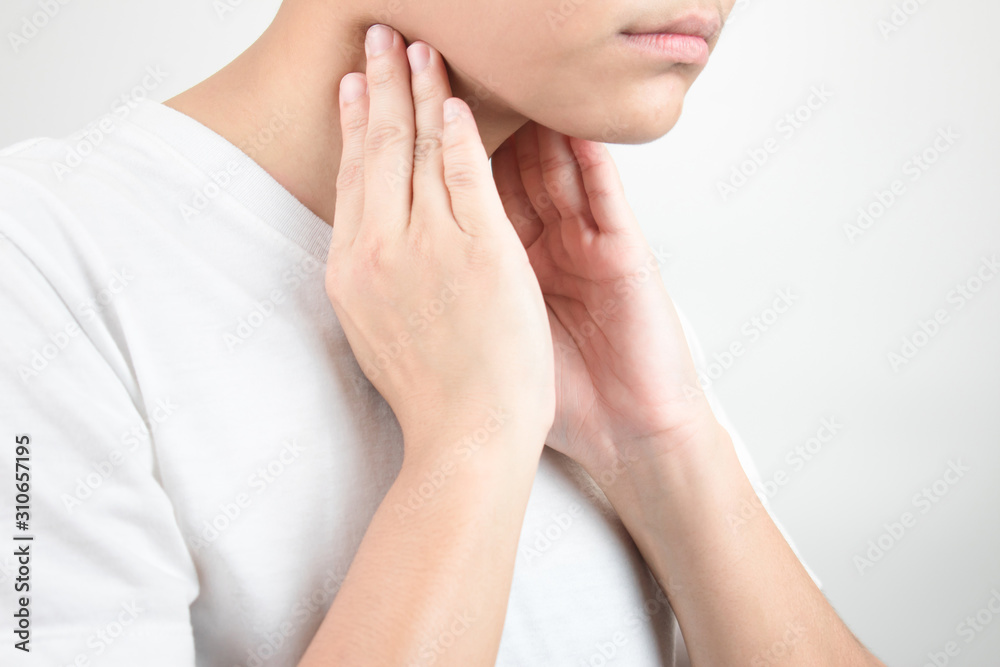 Asian people have a sore throat using two hands to touch the neck. Isolated on white background Asian people have a sore throat using two hands to touch the neck. Isolated on white background