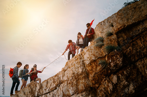 Young asian people climbing up on the mountain,hiking and team work concept.