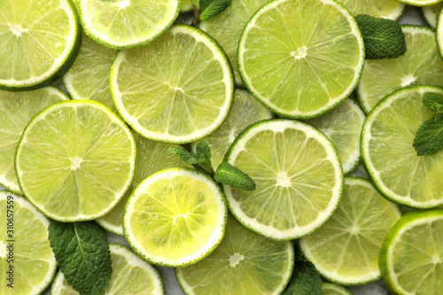 Fototapeta Naklejka Na Ścianę i Meble -  Slices of fresh juicy limes as background, top view