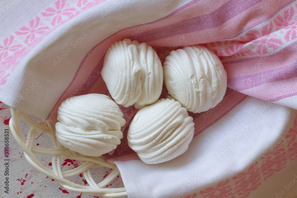 Homemade marshmallows on a white wooden table in a basket.  Pink sweet homemade marshmallow or meringue. top view dessert image. four white cakes . the concept of baking and cooking for the cafe.