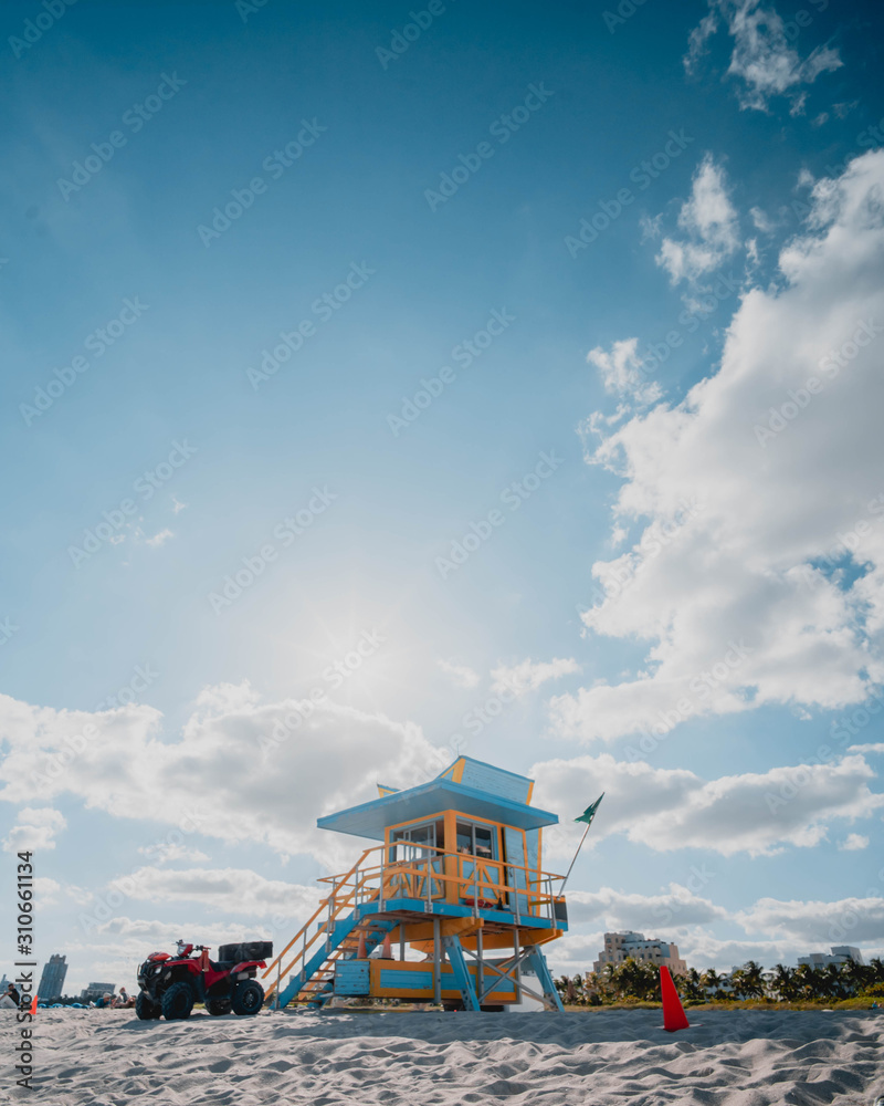 Wide angle vertical photo of yellow lifeguard tower in Miami Beach, Florida, USA