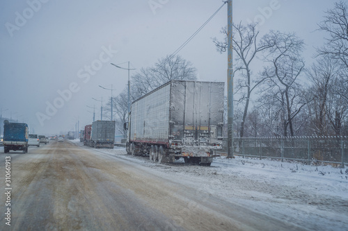 A lot of trucks that can not enter the city due to snowfall. Winter problems on the road photo