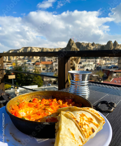 Stewed vegetables in a pan, Turkish pita stand on the table against the background of a blurred background of the city. View from above. photo