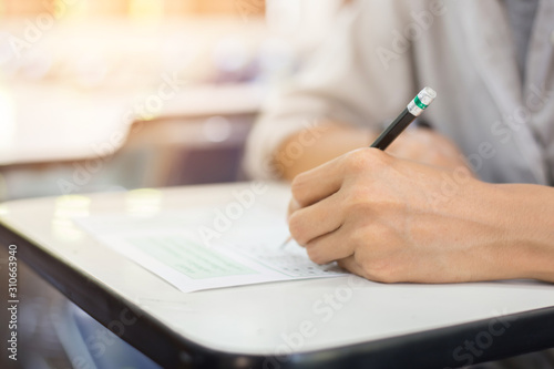 high school,university student study.hands holding pencil writing paper answer sheet.sitting lecture chair taking final exam attending in examination classroom.concept scholarship for education abroad