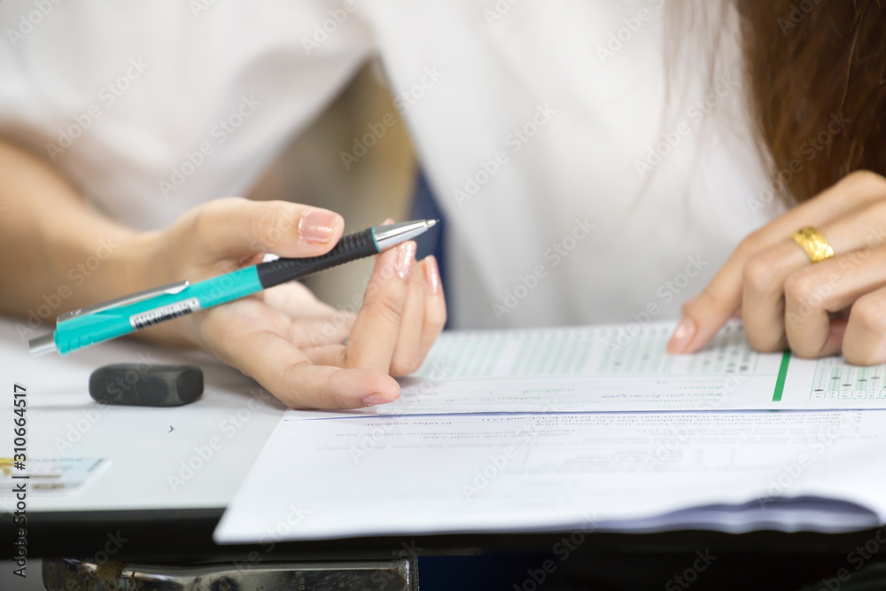 high school,university student study.hands holding pencil writing paper answer sheet.sitting lecture chair taking final exam attending in examination classroom.concept scholarship for education abroad