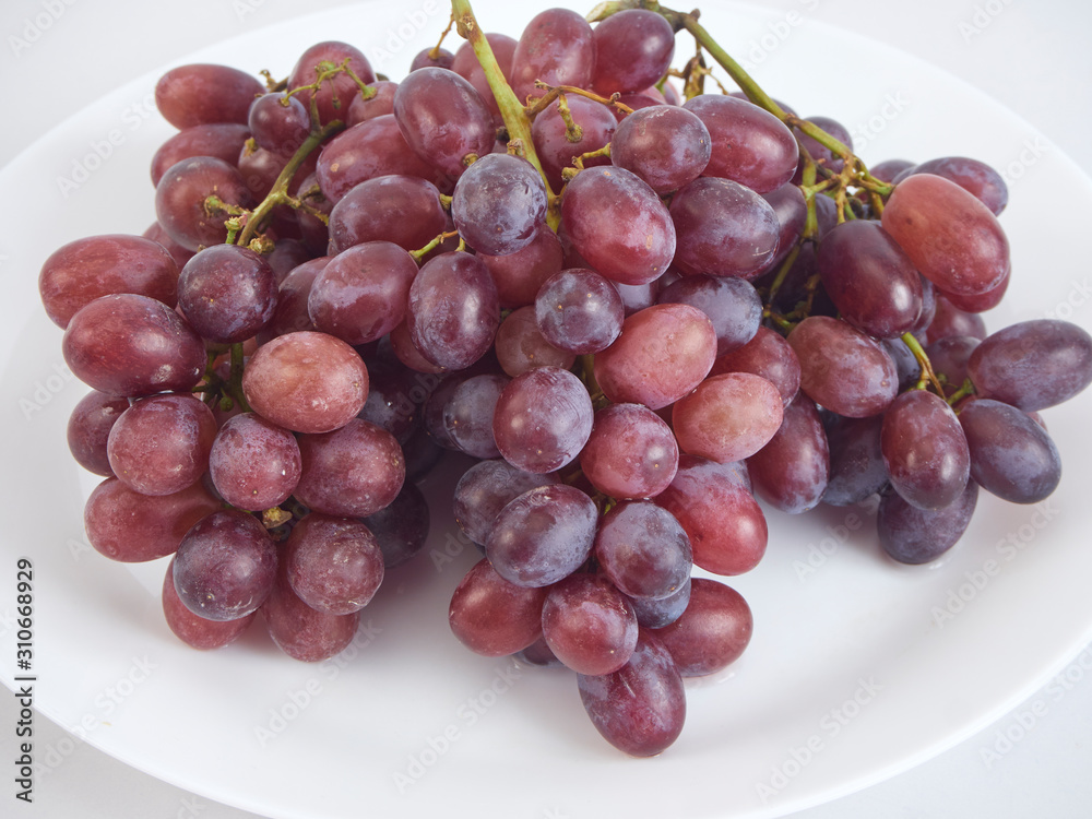Fototapeta premium Bunch of grapes on white plate.