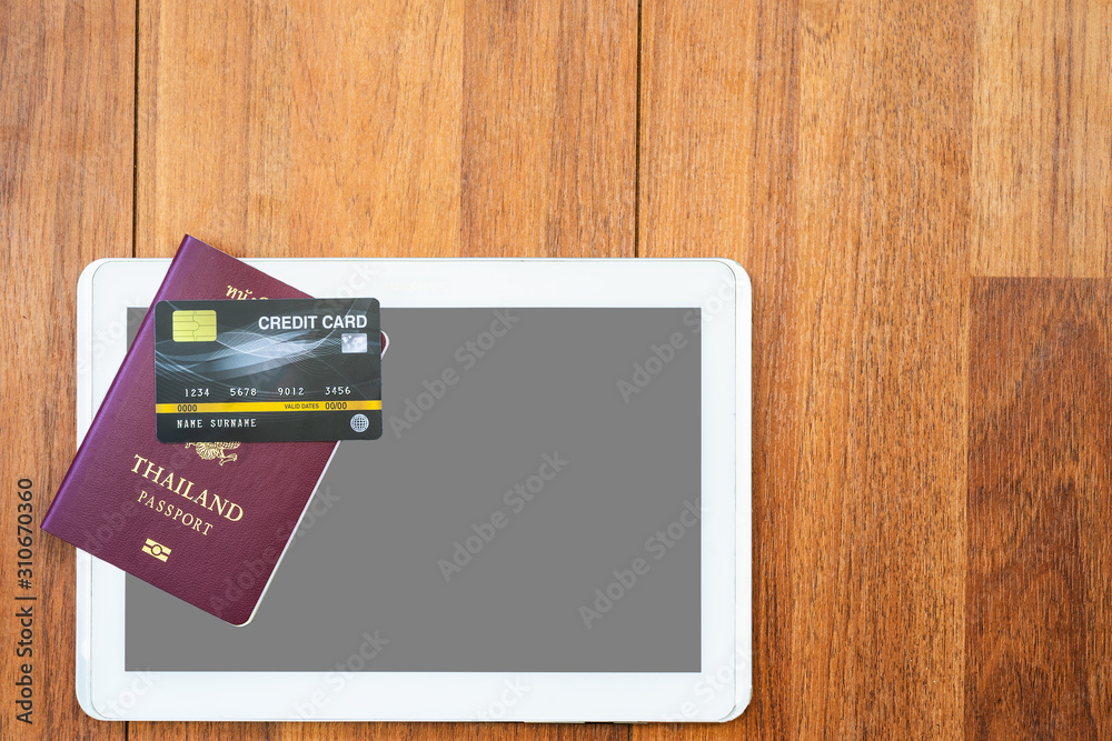 Top view Passport with credit card and digital tablet mock up on wooden desk Top view Passport with credit card and digital tablet mock up on wooden desk
