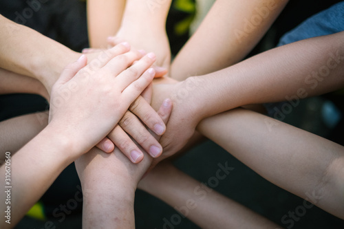 Concept of teamwork: Close-Up of hands business team showing unity with putting their hands together. © boonyawat