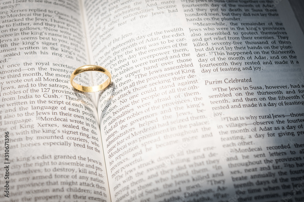 Fototapeta premium gold wedding ring with shadow heart on open Holy Bible in sepia with crackle overlay