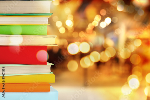 Stack of colorful books on blurred background, space for text. Bokeh effect