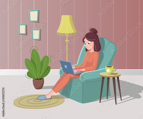 Young woman is sitting in armchair with laptop and cup of coffee or tea. Cozy interior with plant, floor lamp, carpet and pictures.