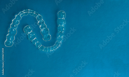 Invisible dental teeth brackets tooth aligners on trendy blue background, Plastic braces dentistry retainers to straighten teeth. Orthodontic temporary removable straighten