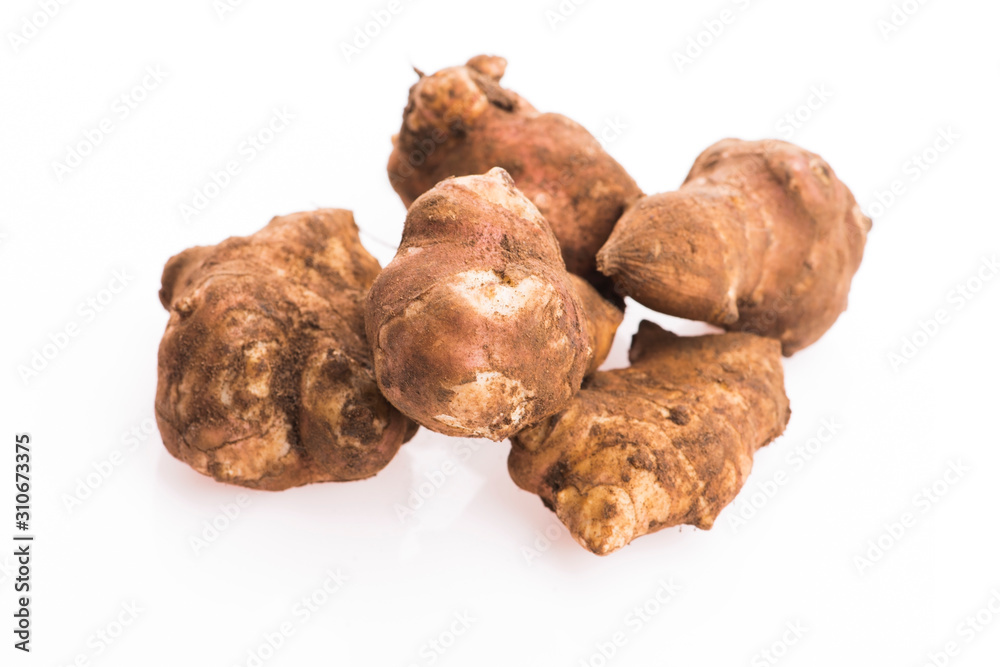 Raw Whole ans sliced Jerusalem artichokes on a white background