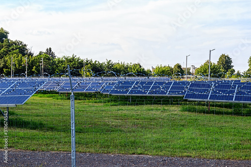 Solar panel on blue sky background. Green grass and cloudy sky.
