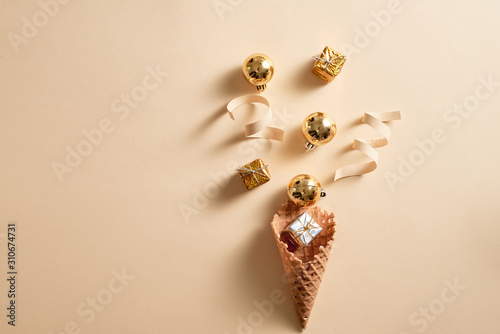 Ice cream waffle cone with ribbon and balls ornament topping. Skin color background