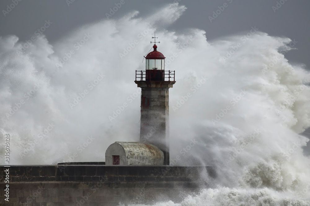 Stormy dramatic wave over lighthouse