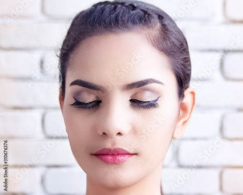 Closeup beautiful face of woman,closed her eyes,show colorful of make up on skin,portrait,model posing,blurry light around