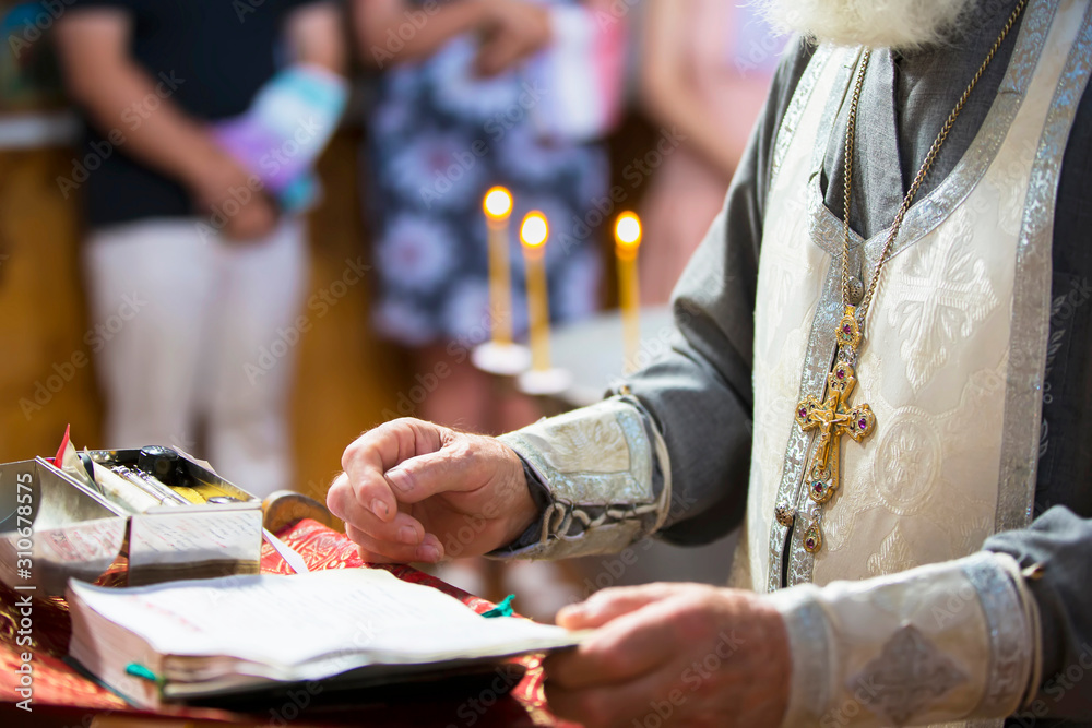 Obraz premium Orthodox religion. Hands of the priest against the background of the cross and candles.