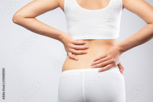 woman holding back in pain. Lower back pain with health care concept.