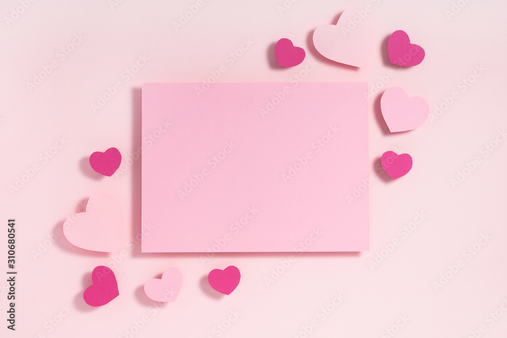 Valentine's day frame composition. Purple and pink hearts blank sheet of paper on pastel pink background. Top view, flat lay, copy space
