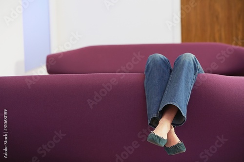 Woman Relaxing Upside Down On Sofa