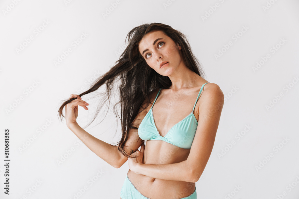 Obraz premium Beautiful young slim girl wearing bikini standing isolated