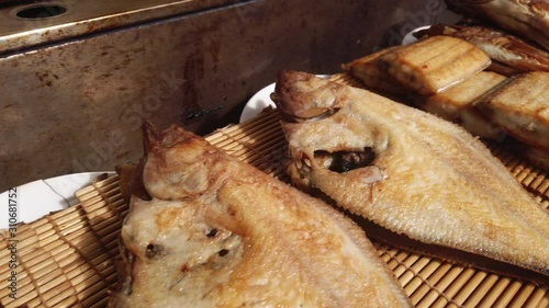 Scenic slow motion video of several fried fishes on table in street market in Busan in South Korea. Beautiful look of delicious and tasty asian street food 