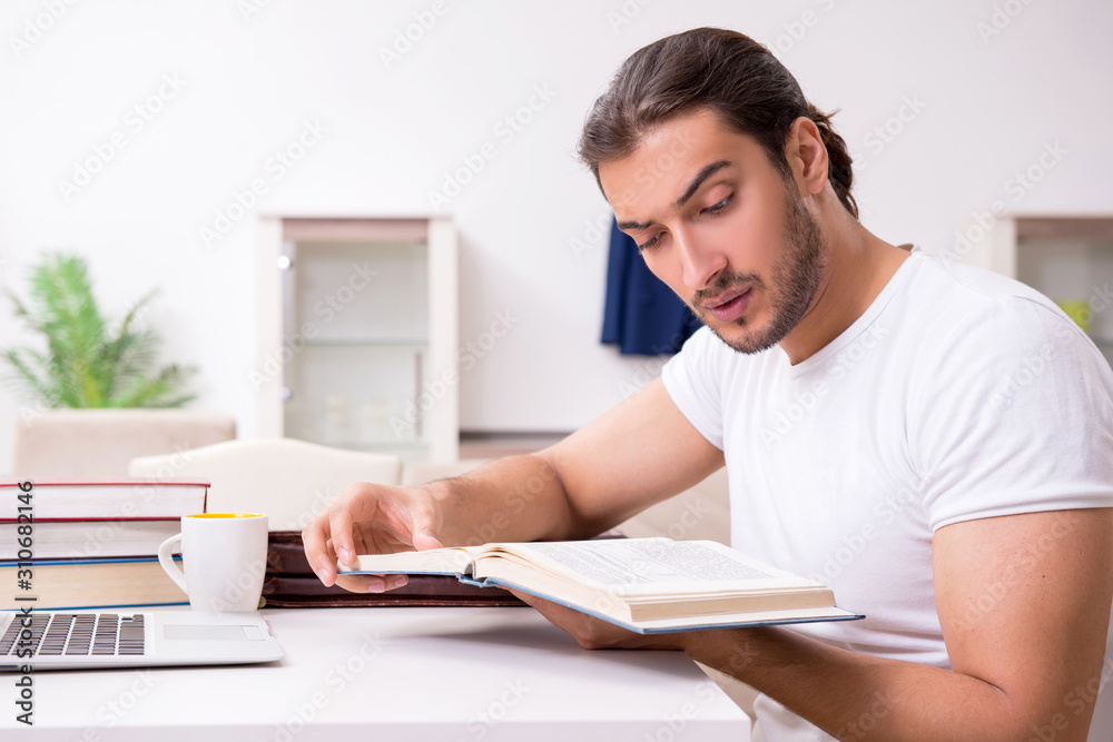 Young male student preparing for exams at home