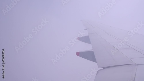 Wing of an airplane flying on the blue sky with fluffy clouds. Tourism transportation with vacation journey. Business and travel concept for add text or website.