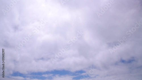 The blue summer sky with white fluffy clouds. Photo from window on the airplane.