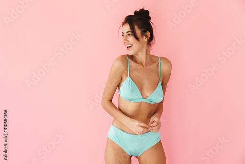 Beautiful young slim girl wearing bikini standing isolated photo