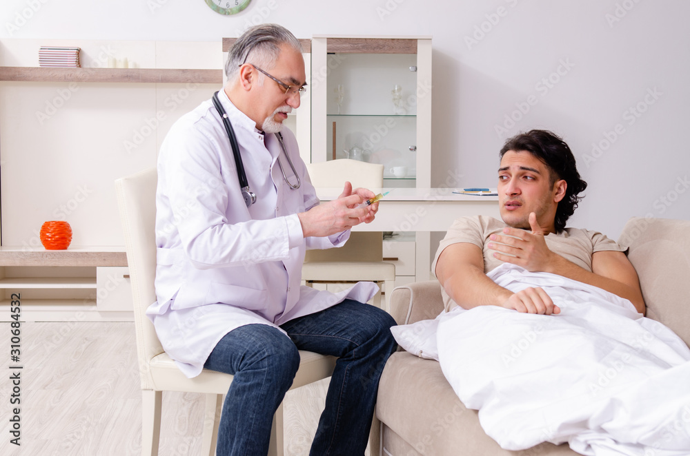 Fototapeta premium Old male doctor visiting young male patient