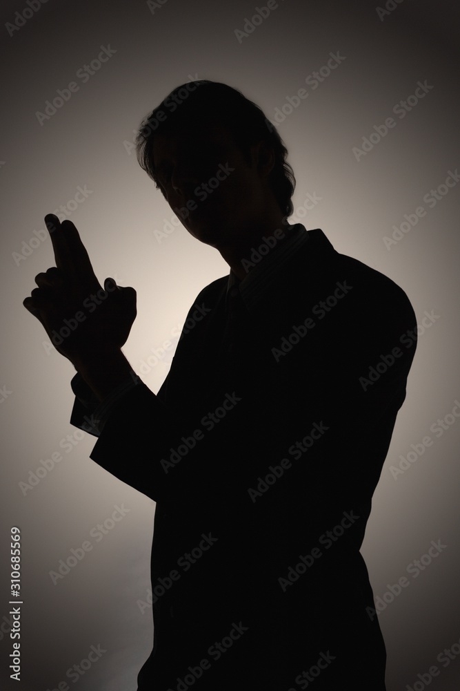 Silhouetted Man Making Gun Shaped Gesture