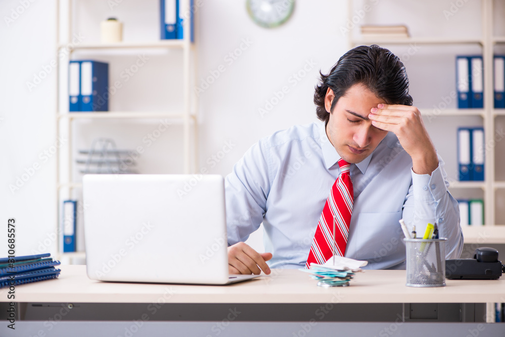 Young male employee suffering in the office Young male employee suffering in the office