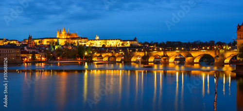 Prague skyline and bridge over river in night