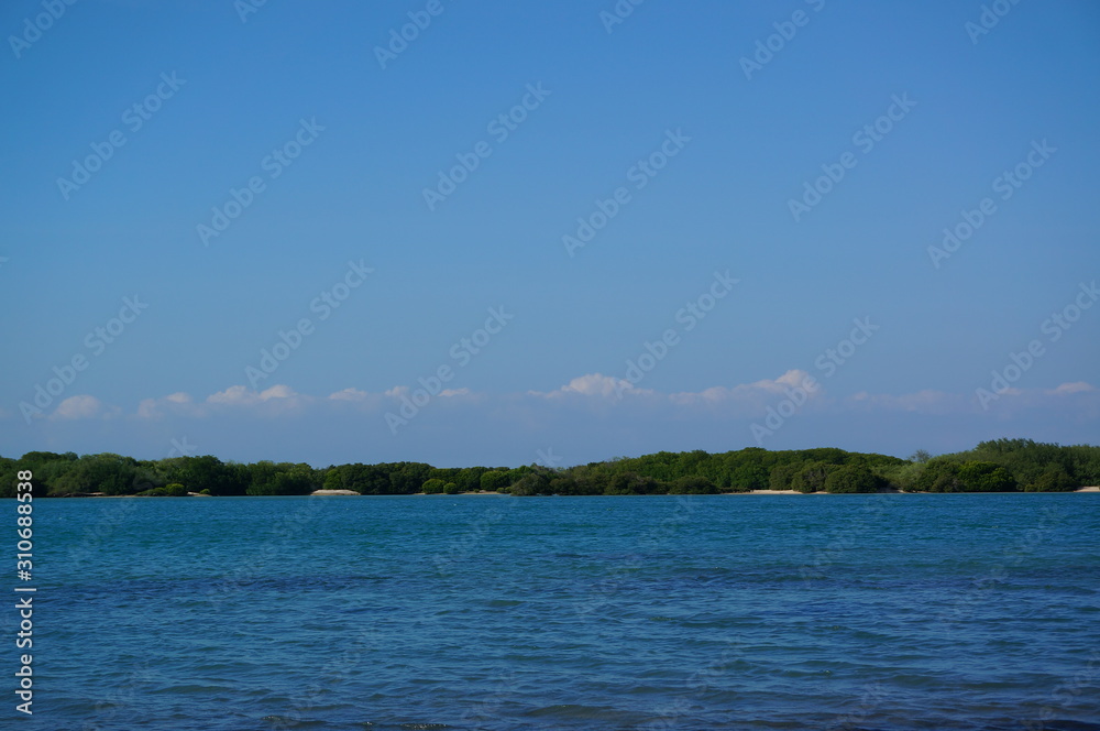 the atmosphere of the beach or the coast before the afternoon with calm waves and sunny weather set against the background of the high seas and mountains or plateaus