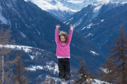 Mädchen springt vor Freude im Schnee