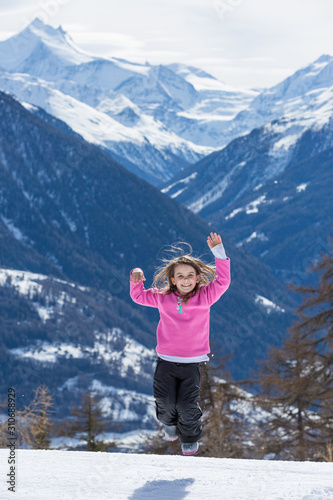 Mädchen springt vor Freude im Schnee