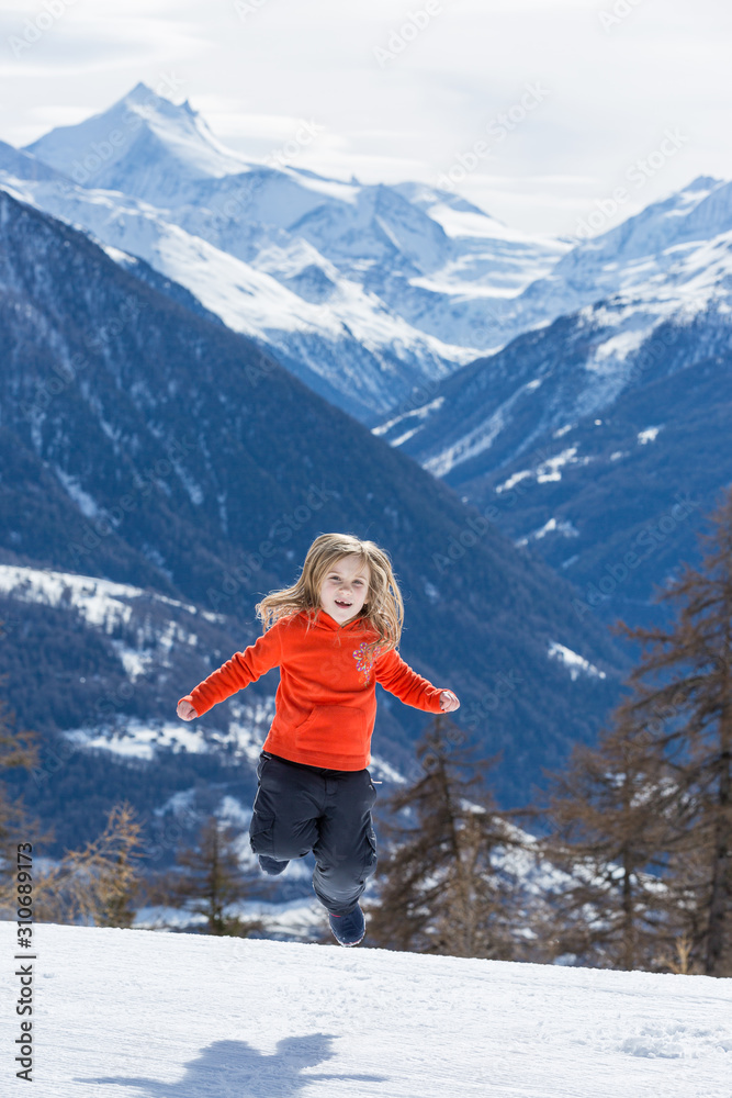 Mädchen springt vor Freude im Schnee