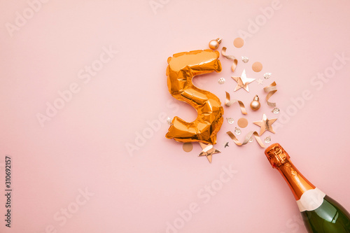 Happy 5th anniversary party. Champagne bottle with gold number balloon. photo