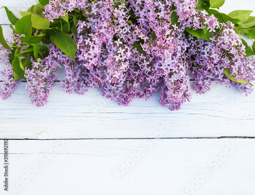 Bouquet of purple lilacs flowers on a light blue shabby wooden background. Vintage floral background with spring flowers.