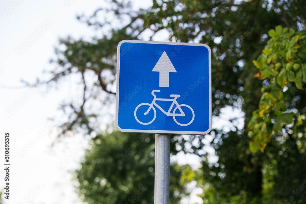 blue square road sign Lane for cyclists close - up on sky background with clouds, tree blue square road sign Lane for cyclists close - up on sky background with clouds, tree
