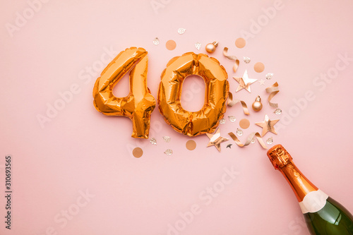 Happy 40th anniversary party. Champagne bottle with gold number balloon. photo