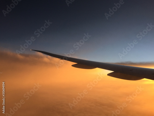 Wing of airplane flying above the clouds