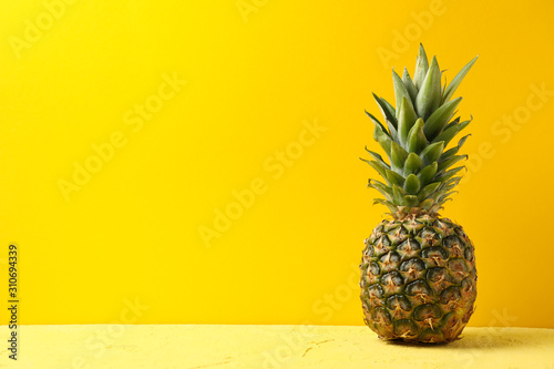 Pineapple on yellow background, space for text. Juicy fruit
