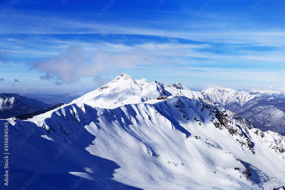 Beautiful mountain covered snow in ski resort Rosa Khotor in Russia. Cold winter sunny day, wonderful view in mountains. Rest and sport.