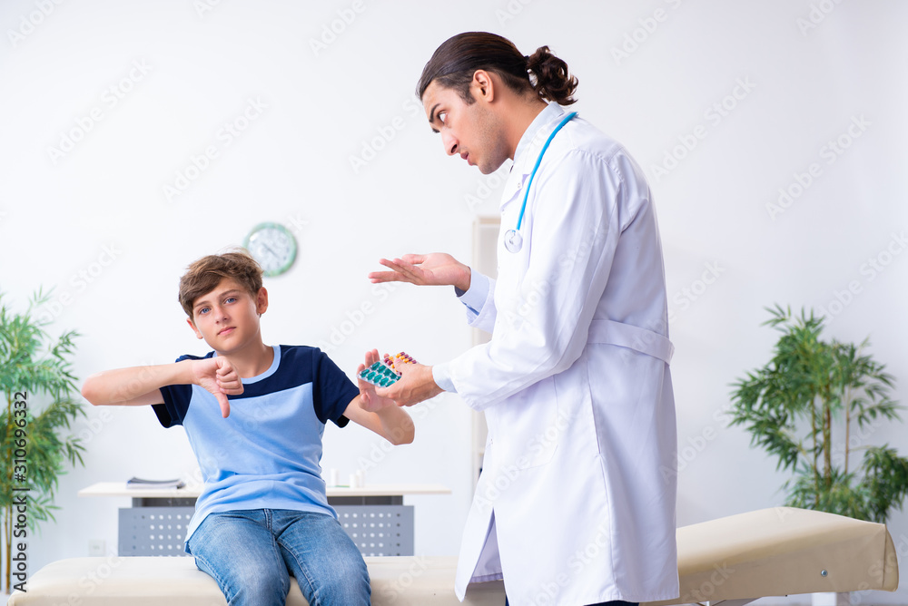 Obraz premium Young male doctor examining boy in the clinic