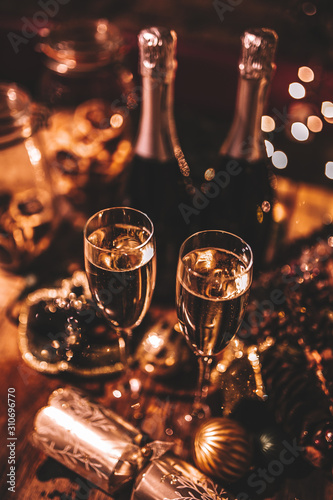 New Year’s Eve celebration with bottles and glasses of champagne. Masquerade themed party. Concept of celebration and luxury lifestyle.